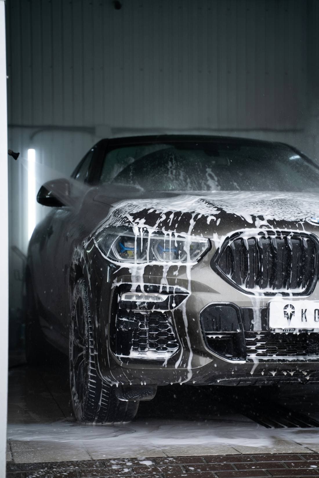 Two-step foam bath on a black luxury car
